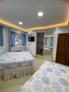 a bedroom with two beds with blue curtains and a mirror at Casa de Heidi in Puerto López