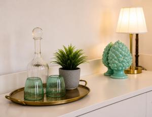 a table with a glass bottle and three green glassases at Villa Costanza sorrento B&b in Sant'Agnello +19 photos