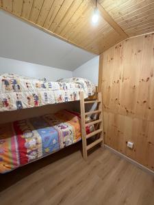 two bunk beds in a room with wooden walls at O Refuxio de Loira in Valdoviño