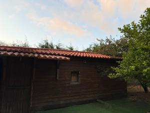 a small wooden house with a red roof at O Refuxio de Loira in Valdoviño