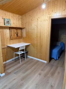 a room with a table and a bed in a cabin at O Refuxio de Loira in Valdoviño