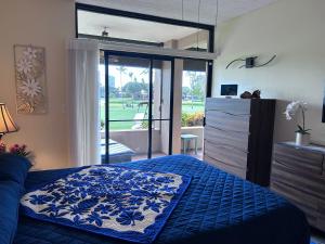 a bedroom with a blue bed and a sliding glass door at Kaanapali Royal C102 in Lahaina +154 photos