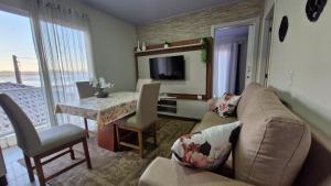 a living room with a couch and a table at Casa Beira Mar Mariscal Superior in Bombinhas