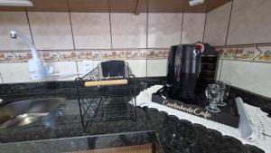 a kitchen counter with two chairs and a coffee maker at Casa Beira Mar Mariscal Superior in Bombinhas +24 photos