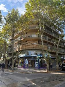 a tall building with trees in front of it at Apartamento Monte Grande Ameghino in Monte Grande
