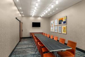 a conference room with a long table and orange chairs at Holiday Inn Express & Suites Salem North - Keizer by IHG in Keizer +25 photos