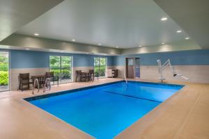 a large swimming pool with blue water in a room at Holiday Inn Express & Suites Salem North - Keizer by IHG in Keizer