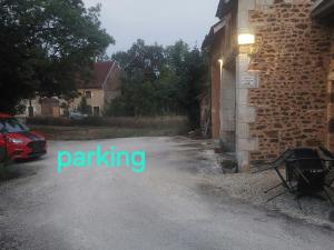 a street sign that says parking next to a building at Les puisayennes in Treigny