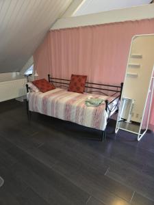 a bed in a room with a pink wall at All Together in Rupelmonde