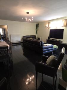 a living room with couches and a flat screen tv at All Together in Rupelmonde