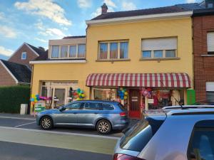 a car parked in front of a yellow building at All Together in Rupelmonde