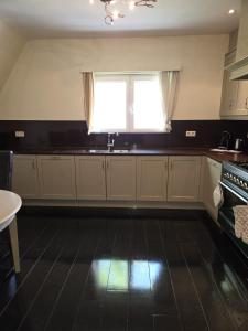 a kitchen with white cabinets and a window and a sink at All Together in Rupelmonde