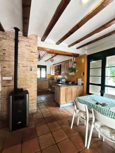 a kitchen with a stove and a table with chairs at La Llar del Magraner in Barraca de Aguas Vivas