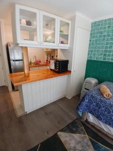 a kitchen with a counter with a microwave and a bed at Departamento en Pucón in Pucón