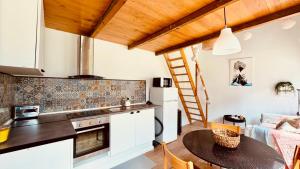 a kitchen with a table and a kitchen with a ladder at Bam’s Farm in Alcobaça