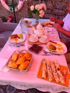a table with plates of food on a pink table cloth at Shegani House in Lin