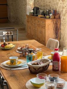 a wooden table with food and drinks on it at Moulin de Carrière, dans un parc de 2 hectares à Uzès in Uzès
