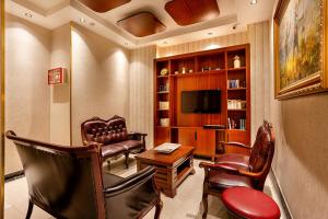 a living room with leather chairs and a television at The Central Hotel in Istanbul