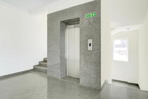 a elevator in a building with a sign on a wall at Townhouse Oak AECS Layout Brookfield in Bangalore +22 photos