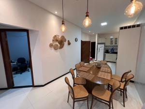 a kitchen and dining room with a table and chairs at Casa inteira com Piscina - 3 Quartos - Área Gourmet - 5 min da Praia in Prado