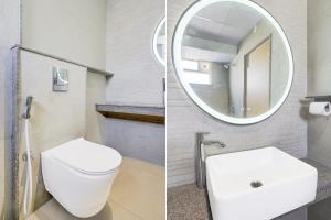 a bathroom with a white toilet and a mirror at Townhouse Oak AECS Layout Brookfield in Bangalore