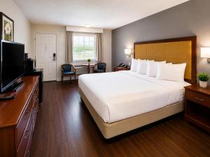 a hotel room with a bed and a flat screen tv at Evergreen Inn in Branson