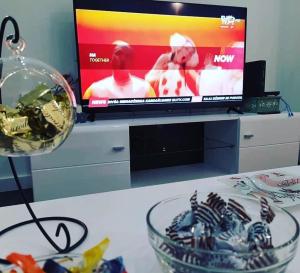 a living room with a television and a table with a lamp at SPA apartman in Kragujevac