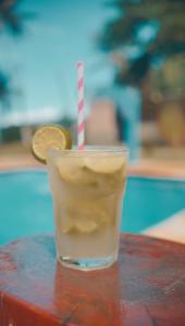 a drink sitting on a table next to a coin at Pousada Villa Mar Porto in Porto De Galinhas