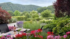 a garden with a table and some flowers at Au fil de la Semois in Bohan