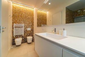a bathroom with a sink and a toilet in it at Cozy Villa with Pool in Como +24 photos