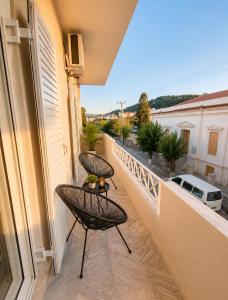 a balcony with two chairs and a table at Aris Studios in Karlovasi