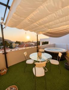 a patio with a glass table and chairs on a balcony at Aris Studios in Karlovasi +9 photos