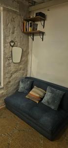 a blue couch with pillows in a room at Studette Rémilly à Versailles in Versailles