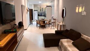 a living room with a couch and a dining room at Casa inteira com Piscina - 3 Quartos - Área Gourmet - 5 min da Praia in Prado