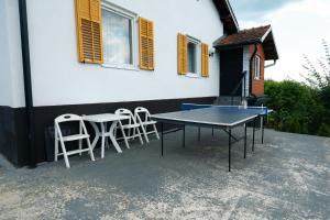 a ping pong table and chairs on a patio at Casa Al Tramonto in Brestovi