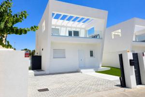 a white house with a fence in front of it at Chalet Laguna Place in Chipiona