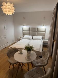 a bedroom with a bed and a table with chairs at Villa Bianca in Mikołajki