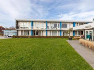 a large building with a lawn in front of it at Coastal Escape w Sauna in Zoutelande