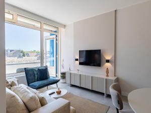 a living room with a couch and a tv at Coastal Escape w Sauna in Zoutelande