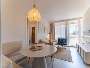 a living room with a table and a couch at Coastal Escape w Sauna in Zoutelande