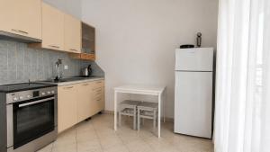 a kitchen with a white refrigerator and a table at Villa Elena in Ormos Panagias