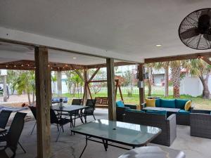 a patio with tables and couches and chairs at El Palmar Cottages LLC Whole House in Clearwater Beach
