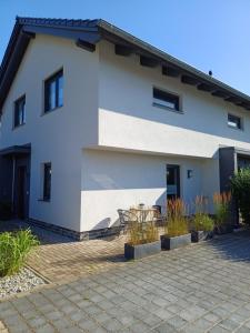 a white house with a patio in front of it at Ferienwohnung BlumenMeer in Karlshagen