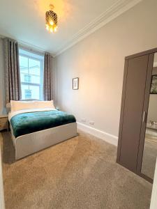 a bedroom with a bed and a window at Homely Away in Plymouth