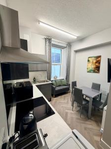 a kitchen and a living room with a table at Homely Away in Plymouth