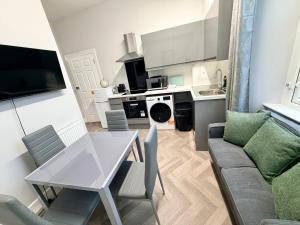 a kitchen and living room with a table and a couch at Homely Away in Plymouth