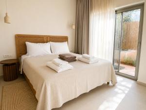 a bedroom with a bed with towels on it at MIRA MARE - Apartments 1 & 8 in Stavros