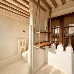 a bathroom with a toilet and a window at Kilele House in Lamu +4 photos