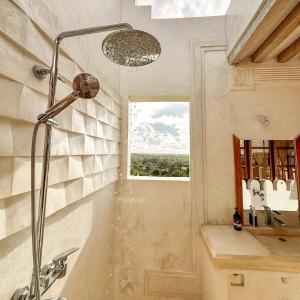 a shower in a bathroom with a sink and a window at Kilele House in Lamu