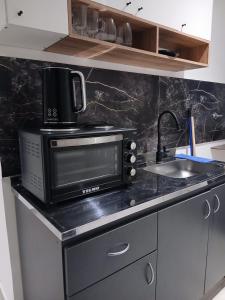 a kitchen counter with a microwave and a sink at Monoambiente en el centro de Zarate in Zárate